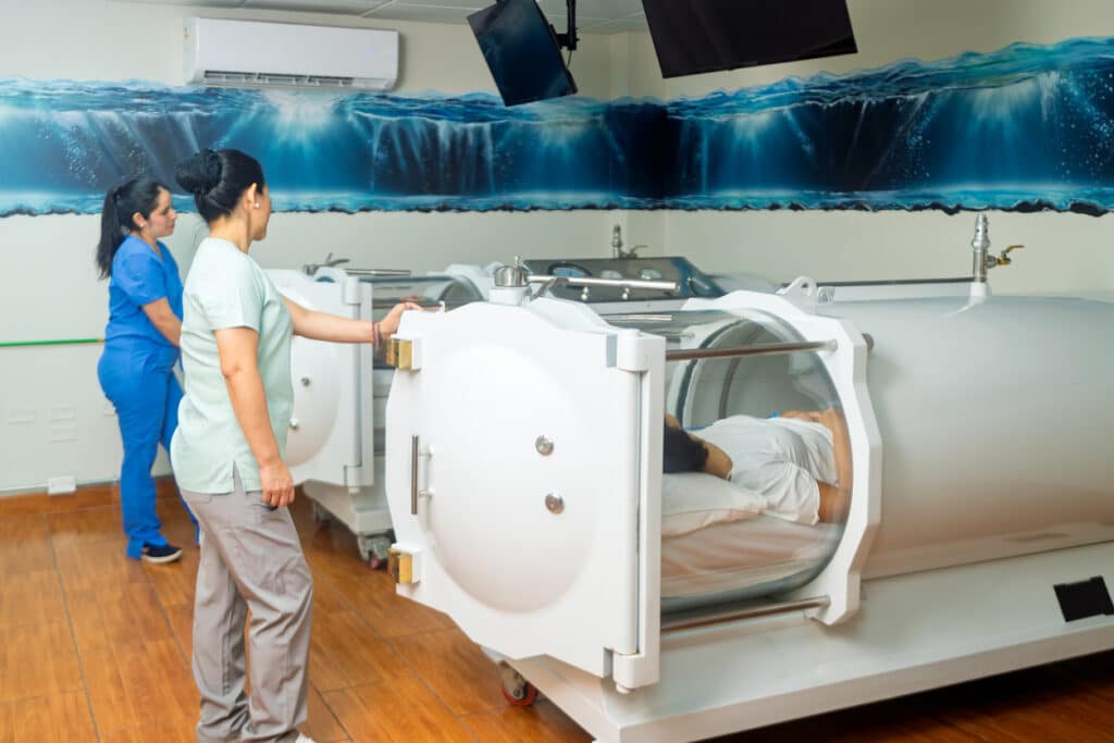 Senior adult receiving hyperbaric oxygen therapy in medical chamber