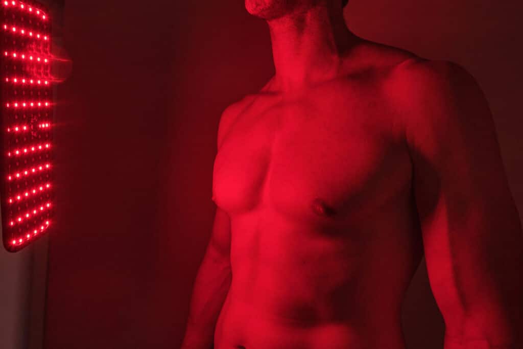 Male torso benefiting from innovative red light led panel for wellness and skin health